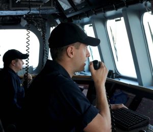 Ofițer de punte utilizând radioul VHF pe puntea de comandă a unei nave militare - echipamente de radiocomunicații navale.